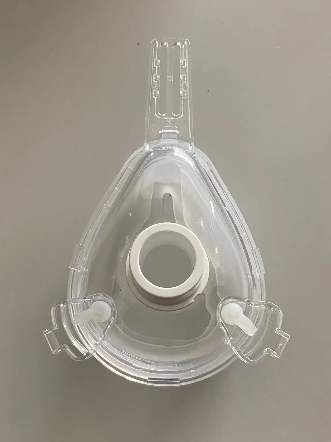 Assembled clear mask with its connector ring and headgear clips in place